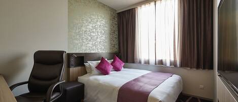 Habitación de hotel con cama, escritorio, silla, ventana con cortinas y pared con diseño texturizado.