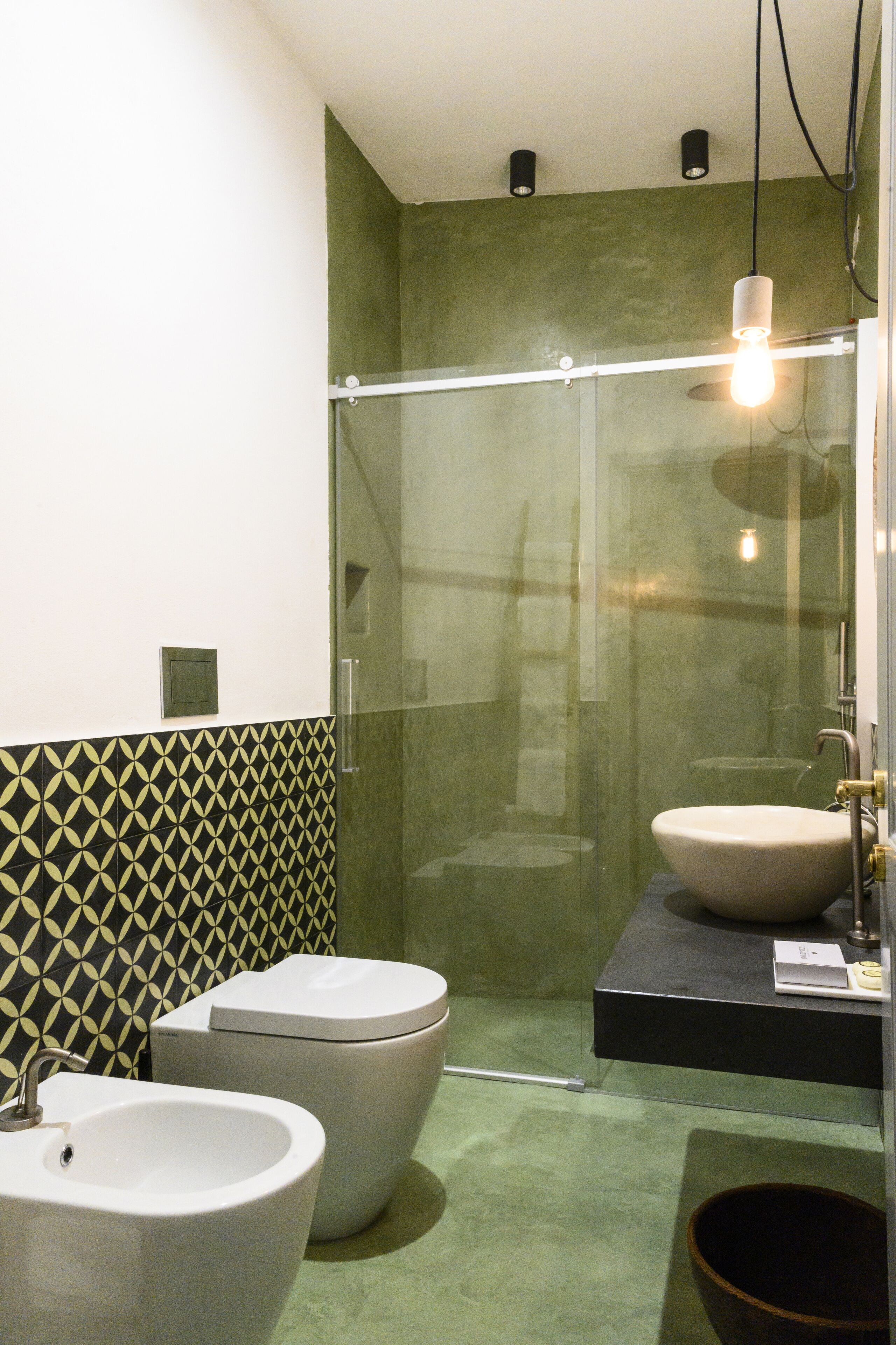 A bathroom with two sinks, a toilet, and a shower enclosure.