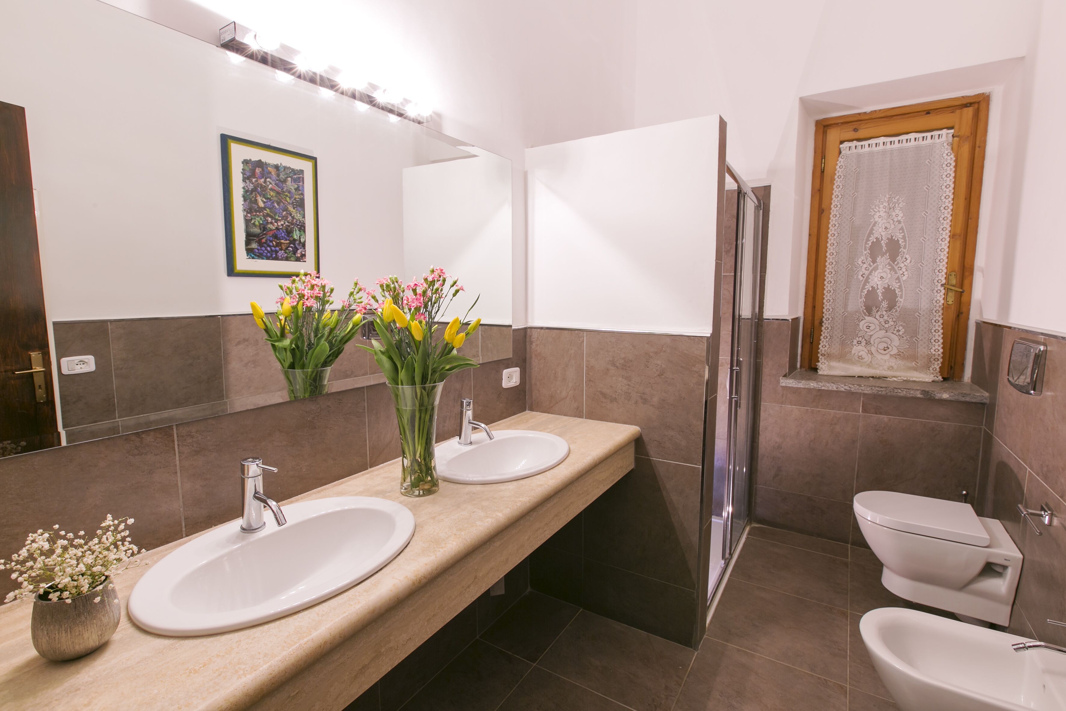 A bathroom with two sinks, a shower, and a toilet.