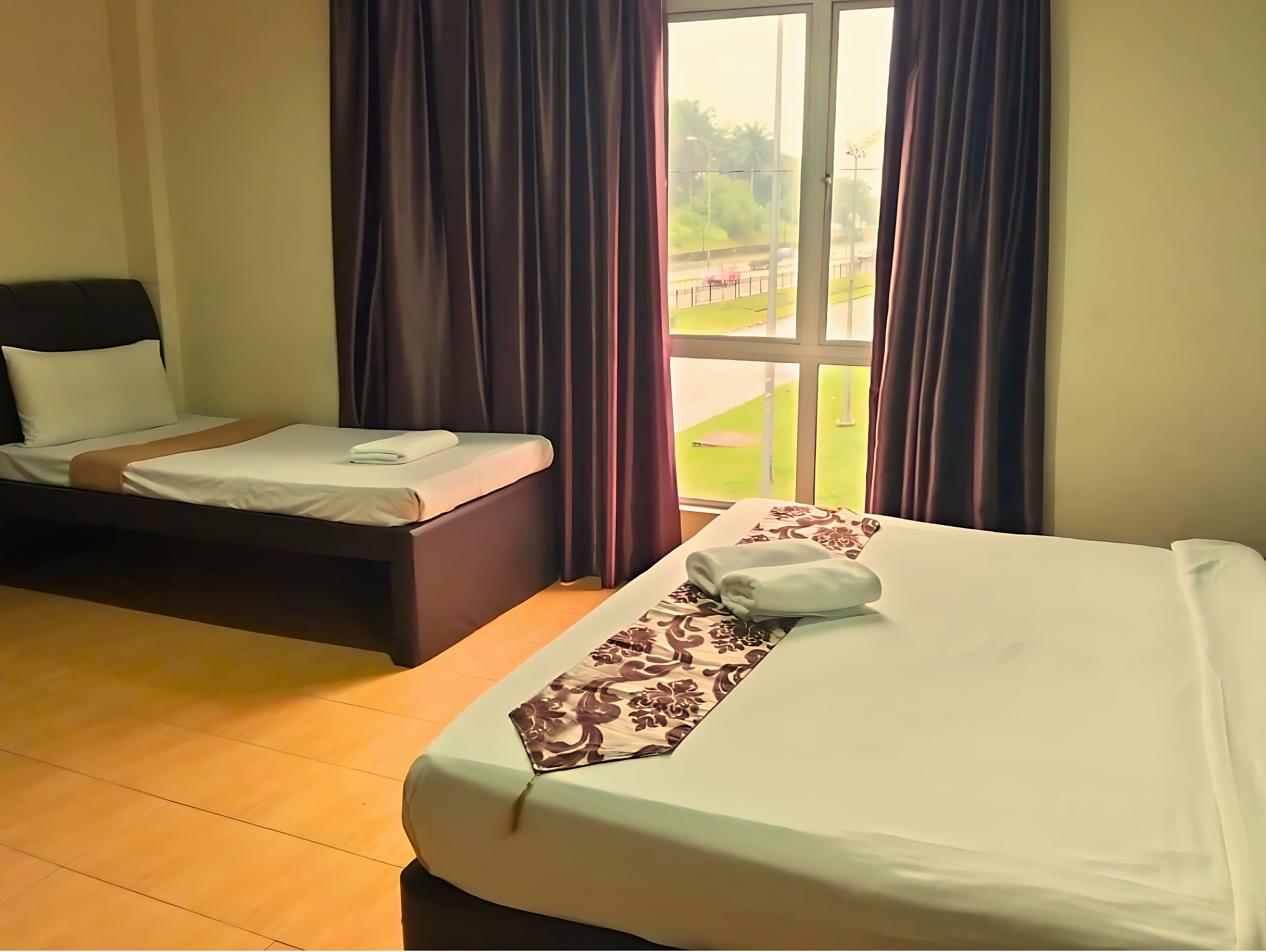 Habitación de hotel con dos camas, un ventanal grande y vistas al exterior.
