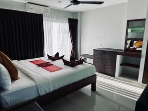 A modern bedroom with a bed, a desk, and a dresser. - Smile Home (Patong)