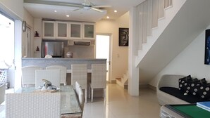 A modern living room with a dining area, a kitchen, and a staircase. - Villa Fei (Jimbaran)