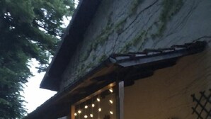 A covered porch with string lights, a bench, and a window. - A o Soâ B&B (Savignone)