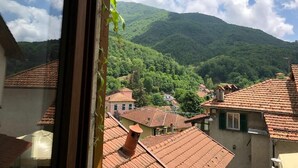 A view of a village with terracotta-roofed buildings and a mountain in the background. - A o Soâ B&B (Savignone)