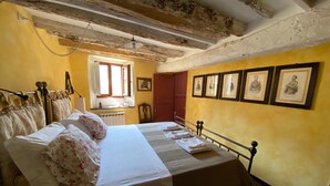 A bedroom with a bed, a window, a radiator, and framed pictures on the wall. - A o Soâ B&B (Savignone)
