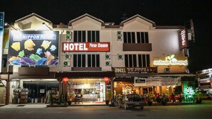 Un hotel llamado "New Dawn", con un anuncio de "NIPPON PAINT" y "restoran kemang" cerca.