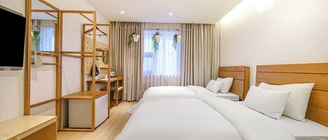 A hotel room with a bed, a desk, a chair, a TV, and a window with curtains.