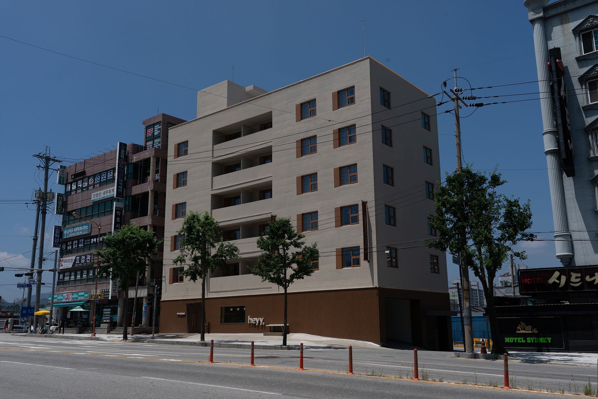 A multi-story hotel with a modern design, featuring a flat facade and a series of balconies.
