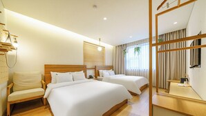 Une chambre d’hôtel avec deux lits, une chaise en bois, un bureau et un miroir.