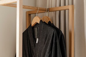 A wooden hanger rack with a black garment hanging on it. - Chuncheon Hey Hotel (Chuncheon)