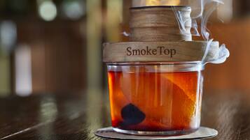 Un recipiente de vidrio con tapa de madera etiquetado como "SmokeTop" sobre una superficie de madera.