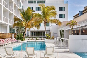 A pool area with lounge chairs and palm trees. - The Sarasota Modern, a Tribute Portfolio Hotel (Sarasota)