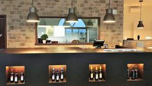 A bar area with stone walls, pendant lighting, and wine bottles displayed in illuminated cases. - Tenuta Lamborghini Golf & Resort (Panicale)