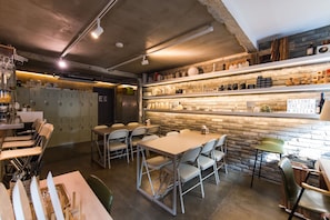 A modern hotel bar with a stone wall, metal lockers, and a welcoming sign. - The Cube Hotel - Hostel (Seoul)