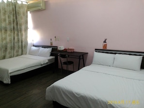 A hotel room with two single beds, a desk, a chair, and a small table. - Caitlyn Hostel II (Taitung)