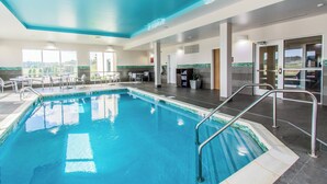 An indoor swimming pool with clear blue water, surrounded by lounge chairs and a sunroof ceiling. - Towneplace Suites by Marriott Evansville Newburgh (Newburgh)