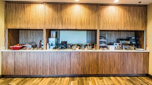 A kitchen area with wooden paneling, a countertop with various appliances, and a tiled floor. - Towneplace Suites by Marriott Evansville Newburgh (Newburgh)