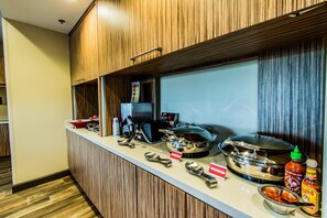 Mostrador de buffet con diversos alimentos y salsas.