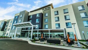 A modern hotel with a covered outdoor seating area and a sign reading "Wyndham Place Suites Marriott". - Towneplace Suites by Marriott Evansville Newburgh (Newburgh)