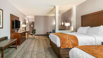 Una camera d'albergo con un letto, una scrivania, una sedia, una televisione e uno specchio.