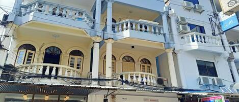 A multi-story building with balconies, a coffee shop, and a tour booking center.