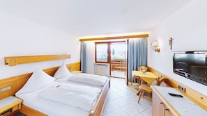 A hotel room with a bed, a desk, a TV, and a balcony with curtains. - Haus Seehang Hotel Garni (Konstanz)