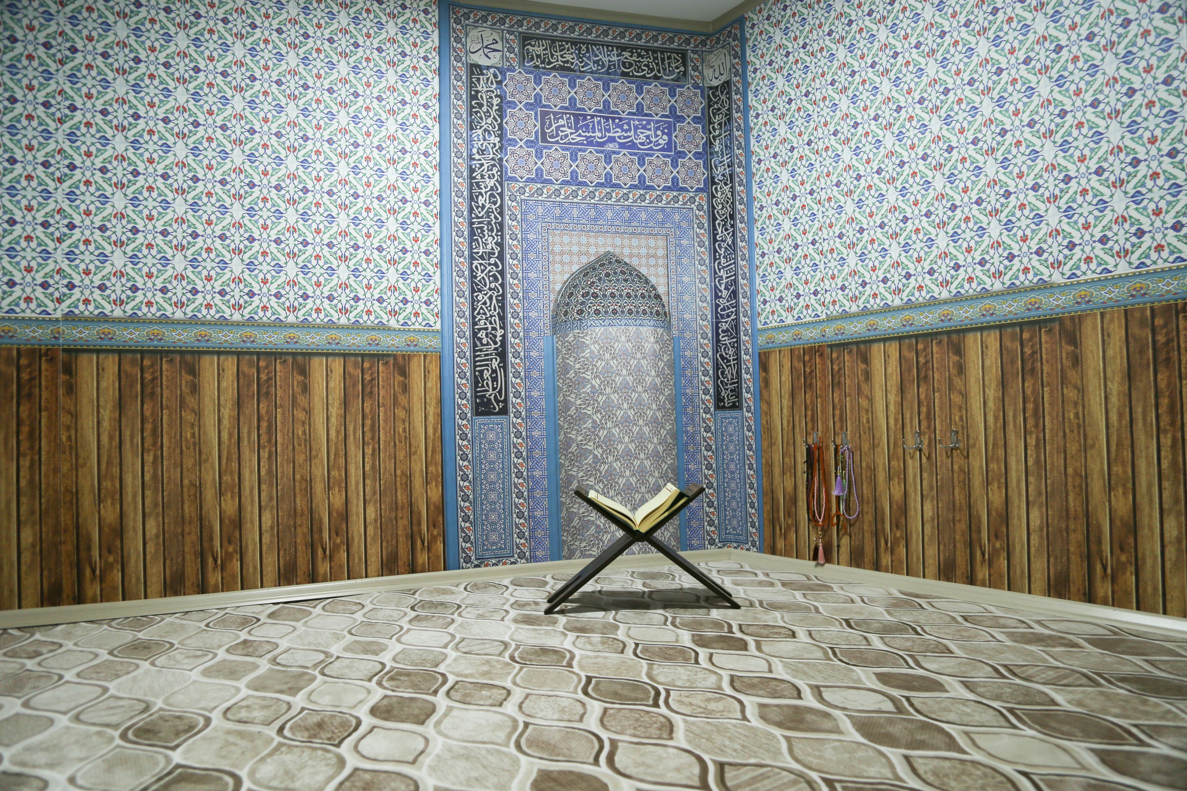 A room with a patterned floor, wooden paneling, and a decorative archway with an open book on a stand.