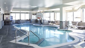 An indoor swimming pool with a basketball hoop, lounge chairs, and a seating area with tables. - Sleep Inn & Suites Oregon - Madison (Oregon)