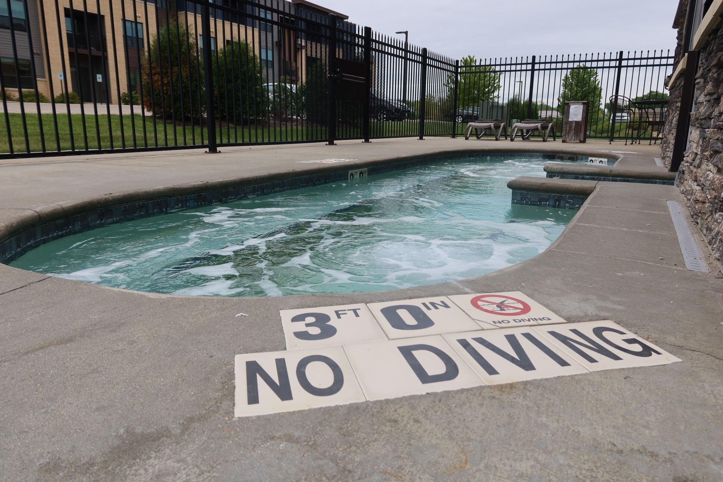 A swimming pool with a '3 FT 0 IN NO DIVING' sign on the edge.