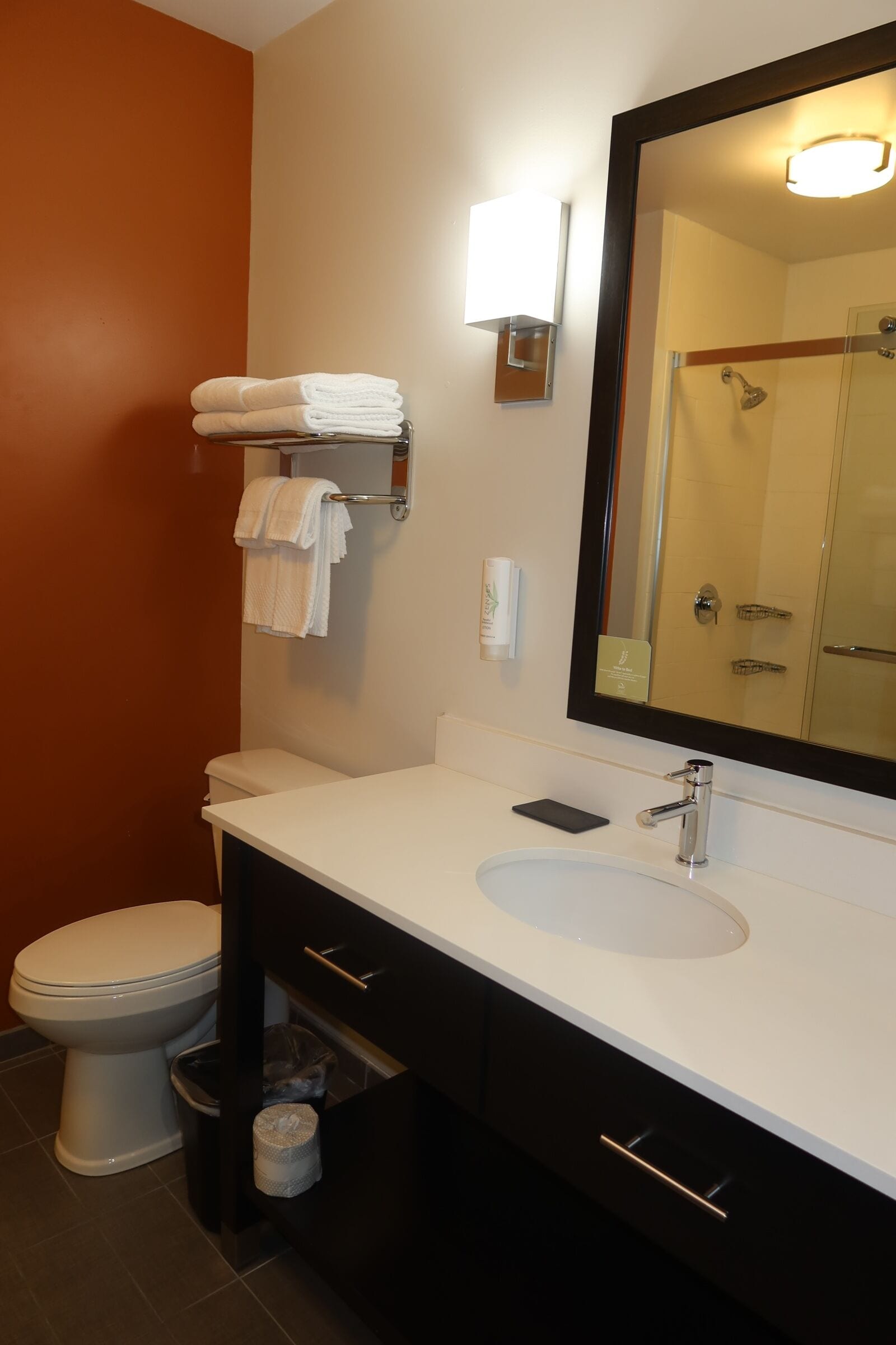 A bathroom with a white sink, a mirror, a towel rack, and a toilet.