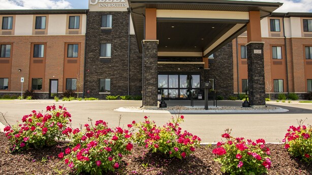 A Sleep Inn & Suites building with a brick facade, large windows, and a covered entrance. - Sleep Inn & Suites Oregon - Madison (Oregon)
