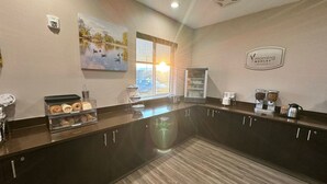A modern kitchen with a central island, a coffee station, and a breakfast sign. - Sleep Inn & Suites Oregon - Madison (Oregon)