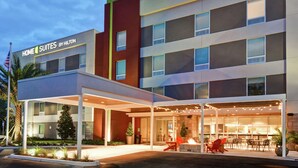 Un hotel de diseño moderno, con un espacio exterior cubierto que incluye asientos y una chimenea.