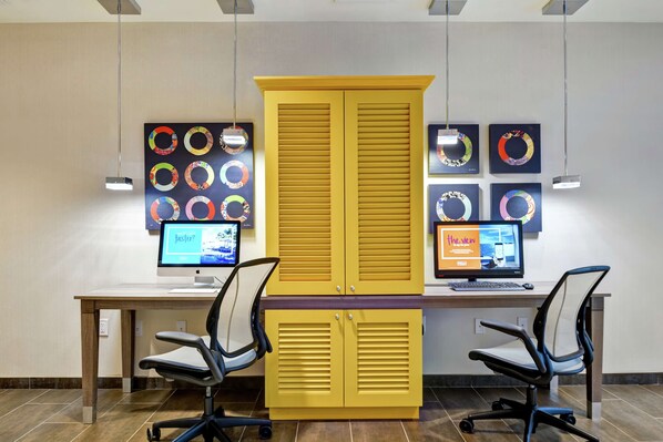 Un espacio de oficina moderno con dos escritorios, dos sillas de oficina y un armario amarillo grande.