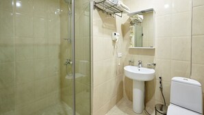 A modern bathroom with a glass-enclosed shower, a pedestal sink, and a toilet. - Green Tower Hotel (Tbilisi)