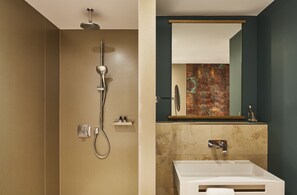 Une salle de bain avec une douche, un lavabo et un miroir.