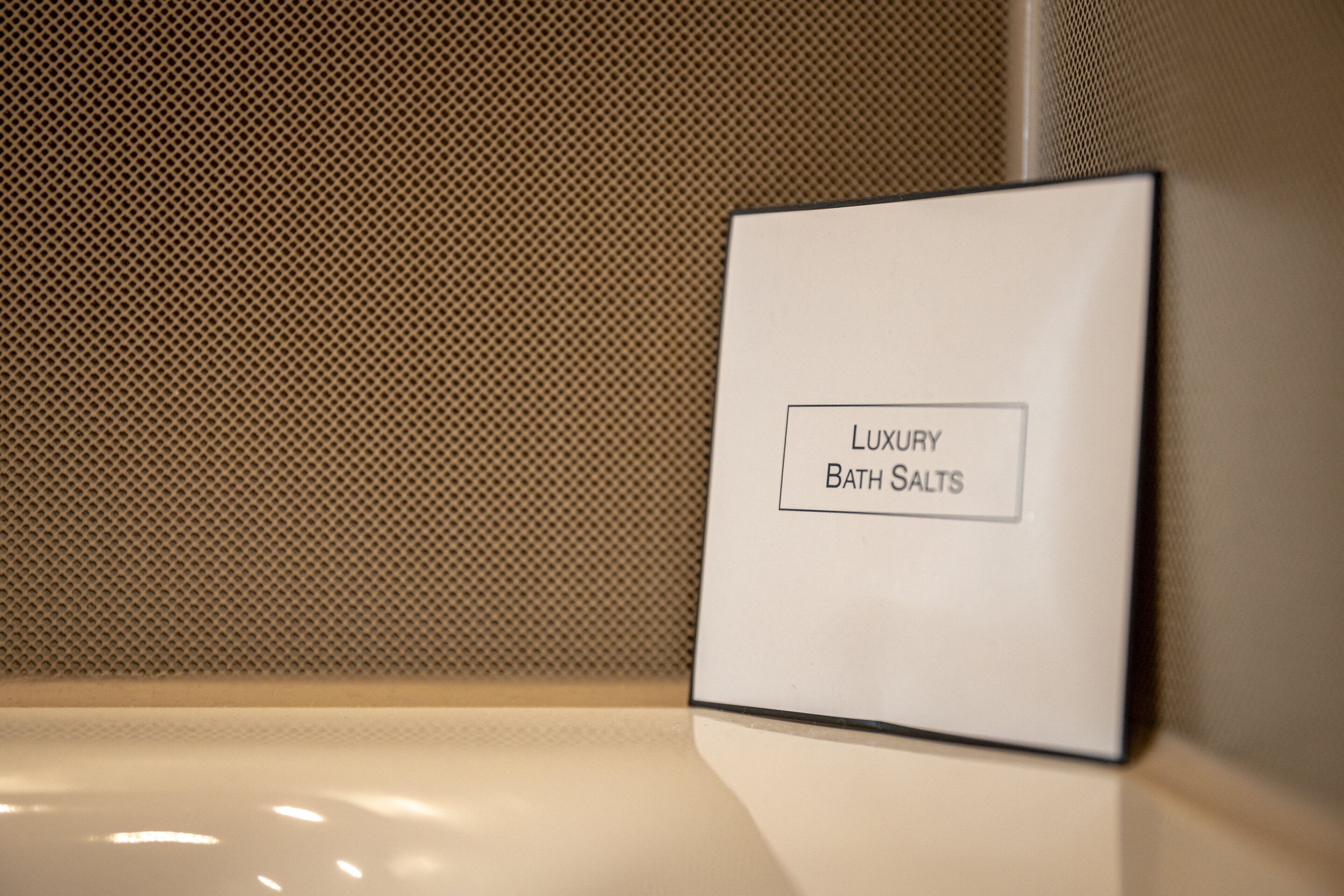 A sign with the text "Luxury Bath Salts" on a white background.