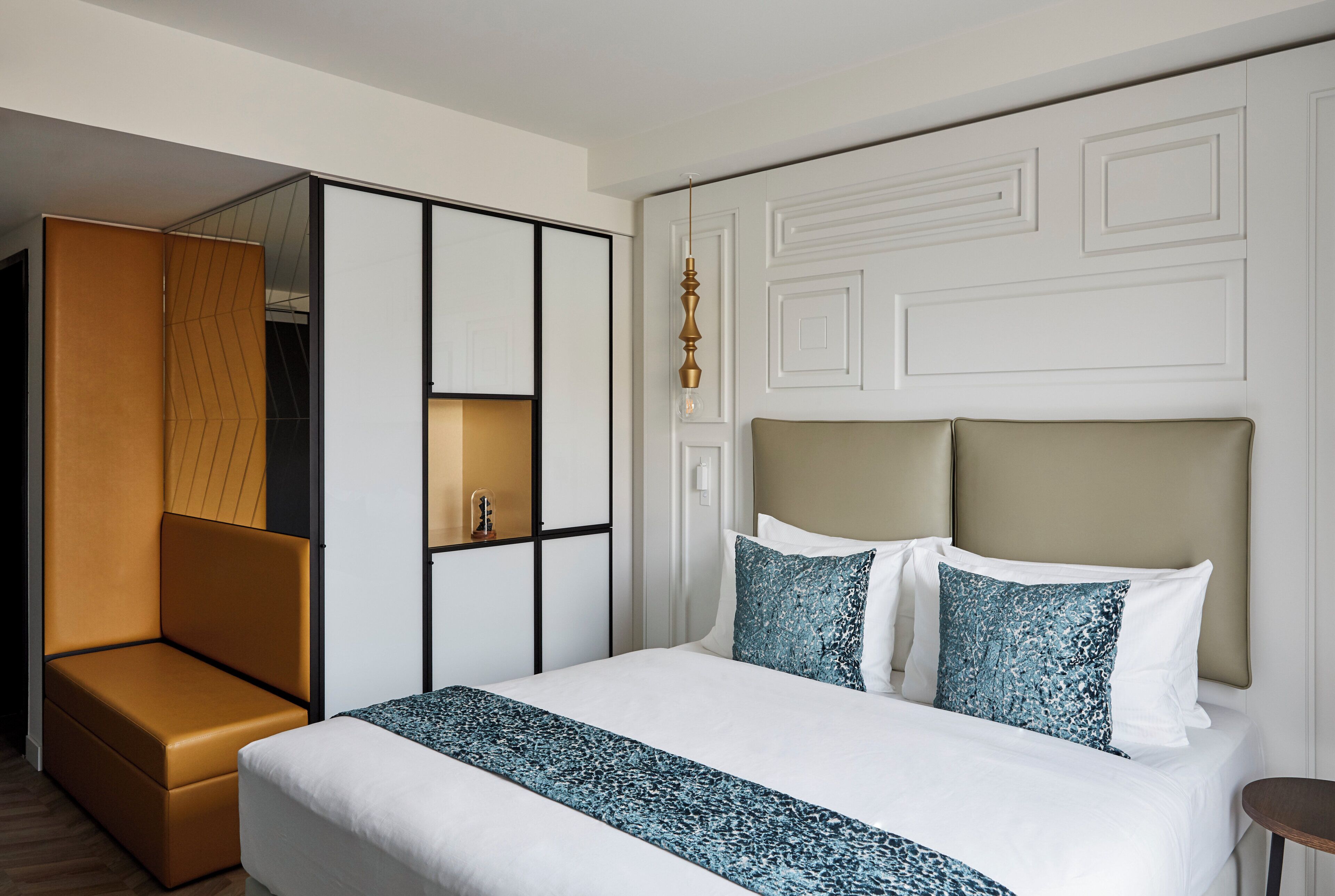 Une chambre d’hôtel comprenant un lit, un coin salon et un miroir.