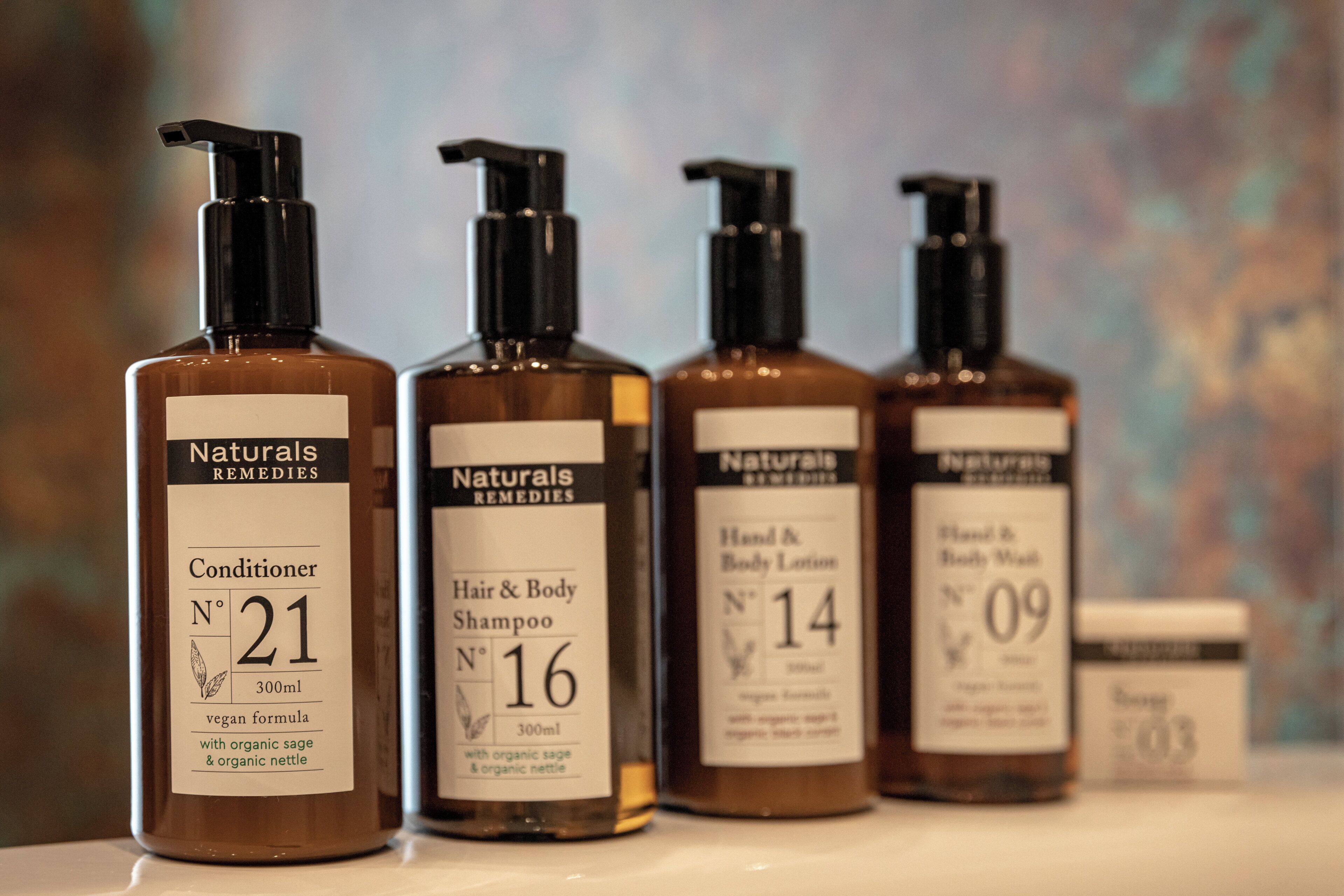 Vier Flaschen von Naturals Remedies Produkten auf einem Regal.