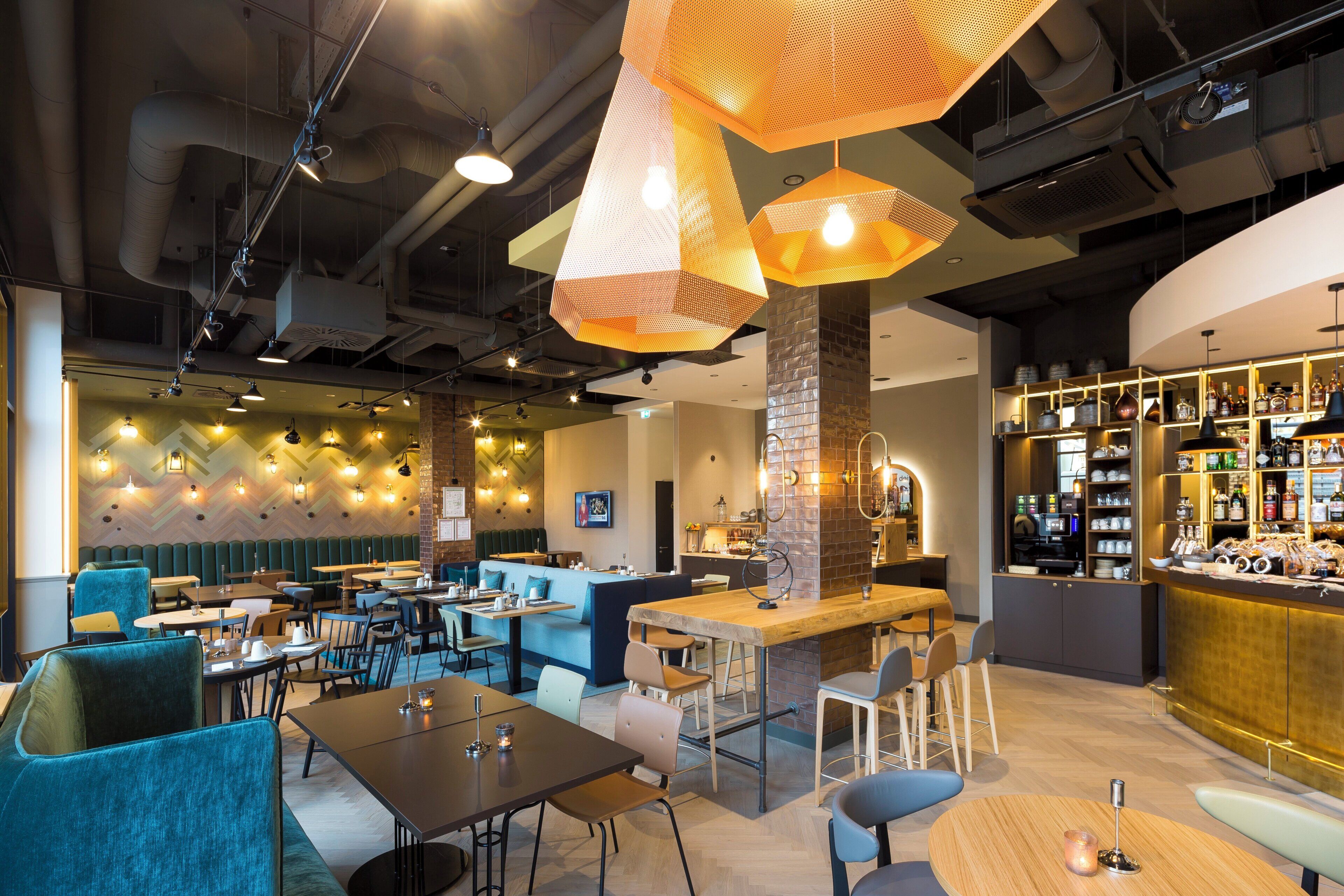 Ein modernes Interieur mit Sitzbereichen, einer Bar und einer sichtbaren Küchenzeile.