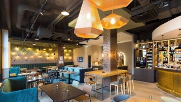 A modern interior with seating areas, a bar, and a visible kitchen area.