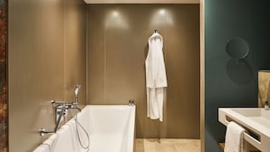 A modern bathroom with a bathtub, a towel rack, and a mirror.