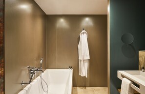 Un baño moderno con bañera, toallero y espejo.