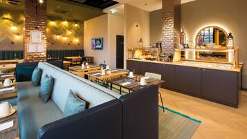 A modern restaurant with a bar area, seating arrangements, and a buffet counter.