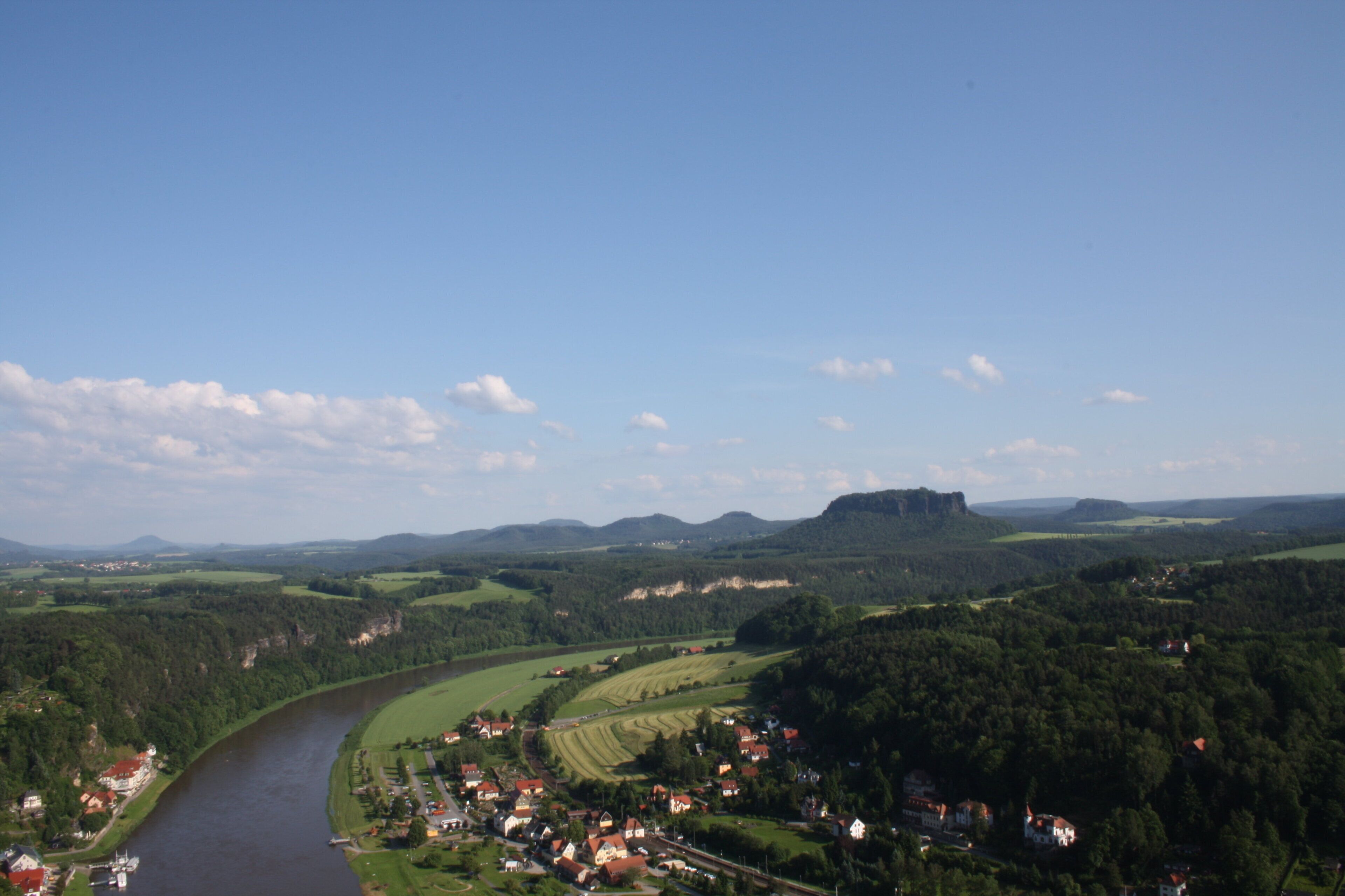 A river flowing through a town with houses and fields.