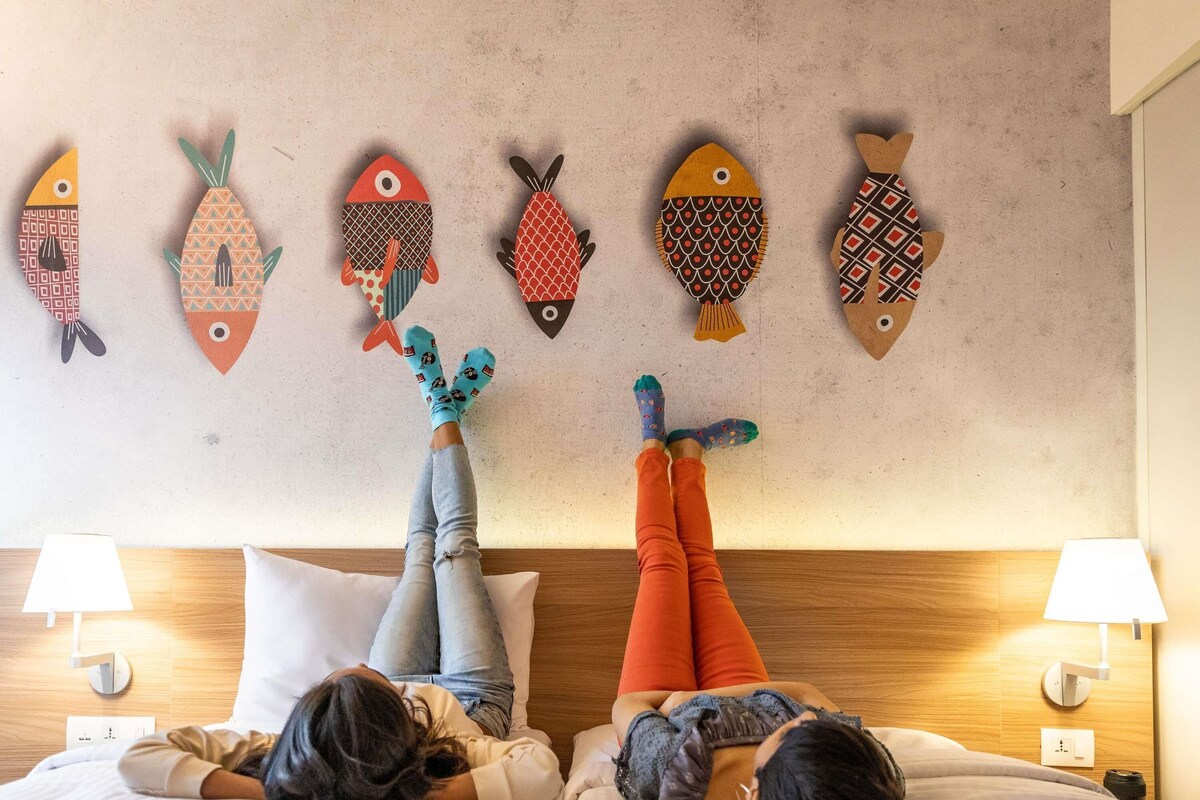 Deux lits, un décor mural représentant des poissons et des lampes de chevet.