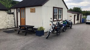 A small building labeled 'BUNKHOUSE' with a picnic table and potted plants in front. - Borgie Lodge Hotel (Thurso)