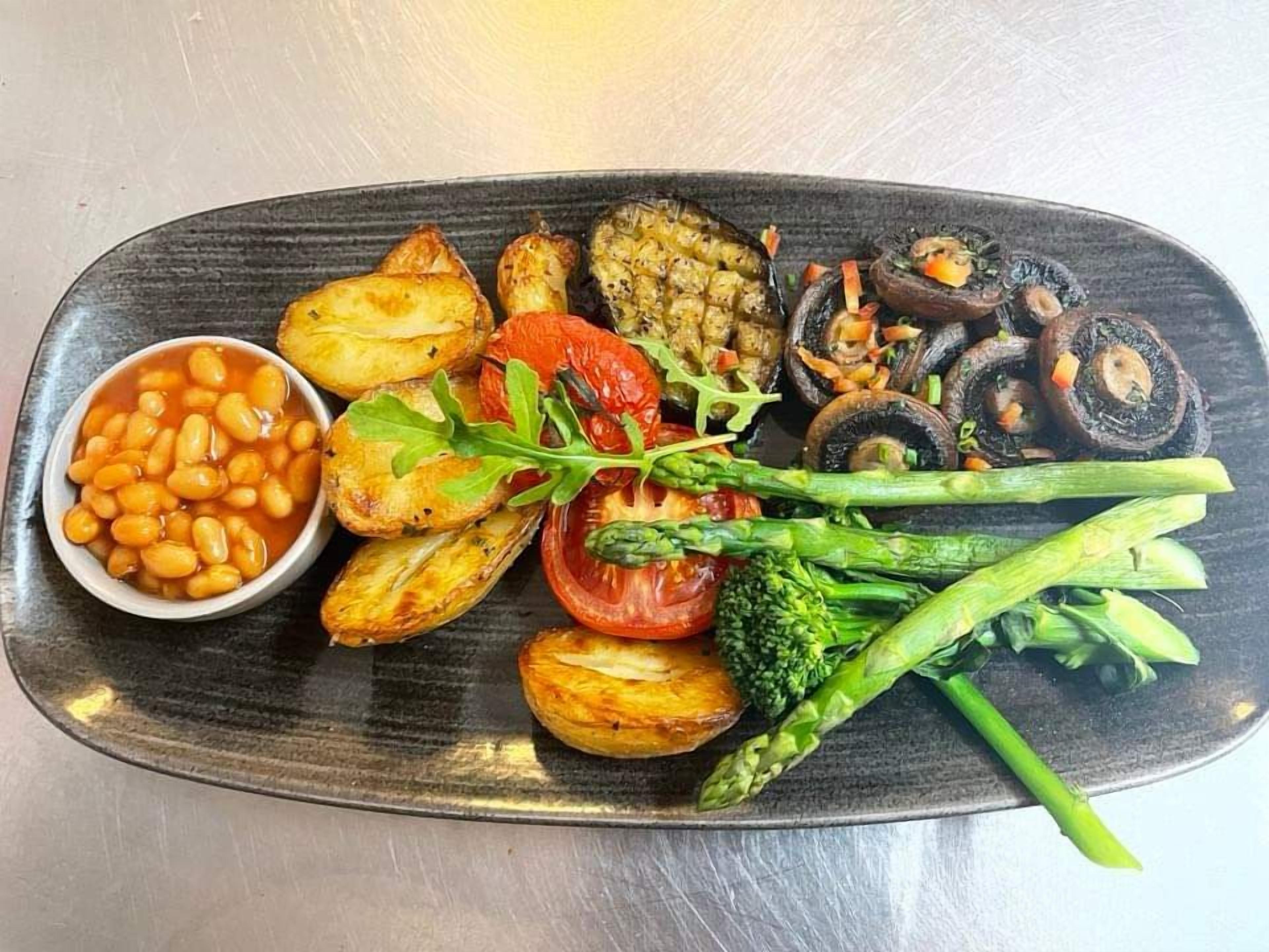 A plate of food with roasted vegetables, beans, and greens.
