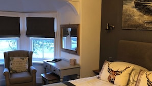 A room with a bed, a desk, a chair, and a window with a view. - Borgie Lodge Hotel (Thurso)