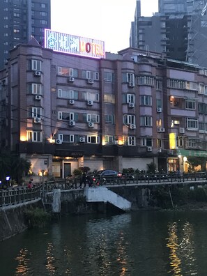 Un hôtel à plusieurs étages, doté de climatiseurs et d’une enseigne.